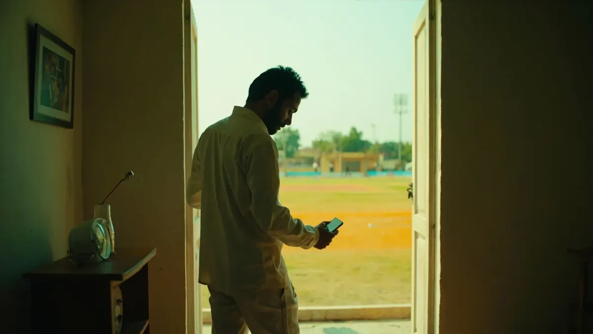Cricket fan setting the phone down and walking toward a ground